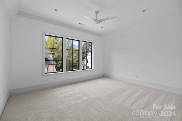 spare room with ceiling fan and light carpet