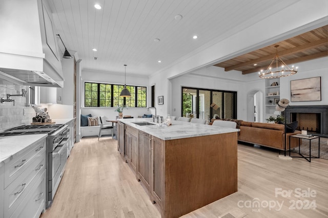 kitchen featuring hanging light fixtures, beamed ceiling, tasteful backsplash, double oven range, and wood ceiling