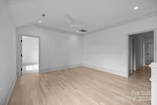 spare room with light wood-type flooring, vaulted ceiling, and ceiling fan