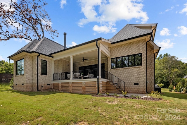 back of property featuring ceiling fan and a yard