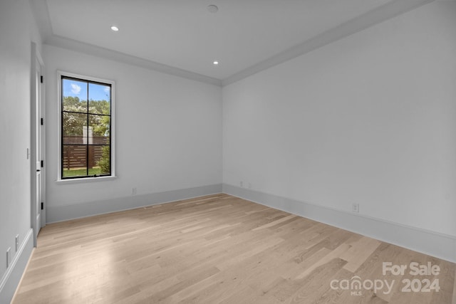 unfurnished room with light hardwood / wood-style flooring and crown molding