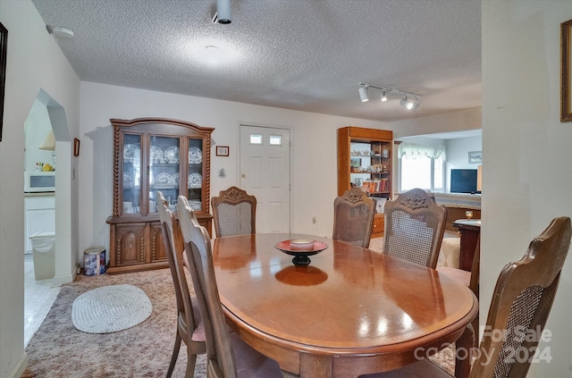 dining room featuring track lighting and a textured ceiling