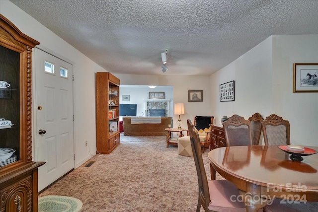 dining space featuring a textured ceiling and carpet floors