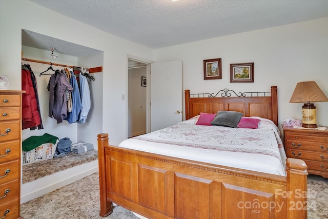 carpeted bedroom featuring a closet and a textured ceiling