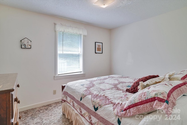 carpeted bedroom featuring a textured ceiling