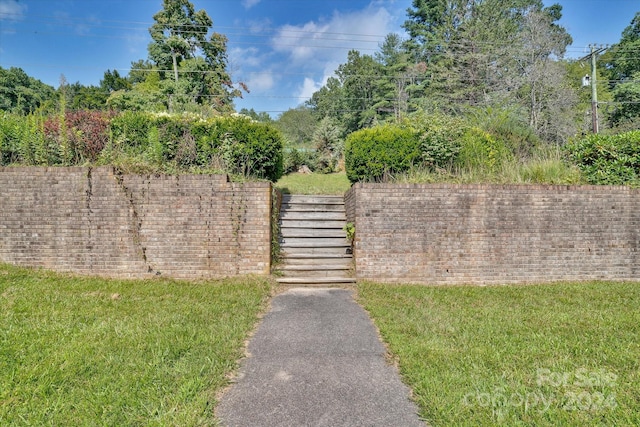 view of gate with a yard