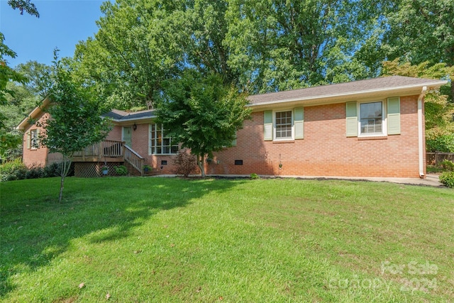 view of front of house with a deck and a front yard