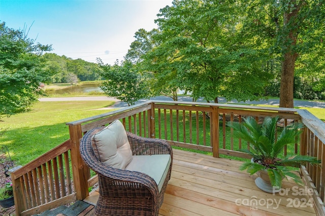 deck with a yard and a water view