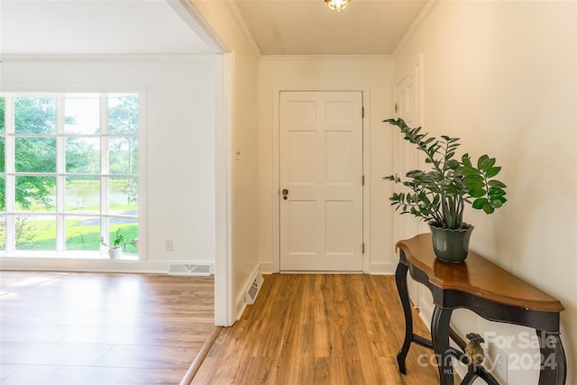 foyer with light hardwood / wood-style flooring and crown molding