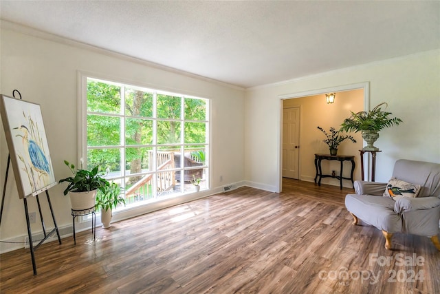 sitting room with crown molding and hardwood / wood-style flooring