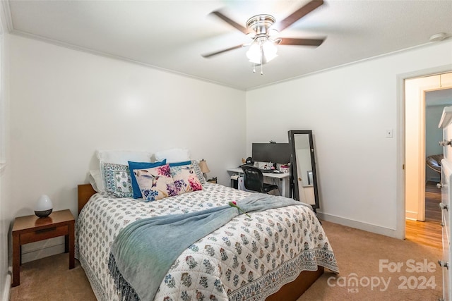 carpeted bedroom with ceiling fan and ornamental molding