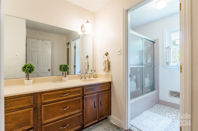 bathroom featuring vanity and bath / shower combo with glass door