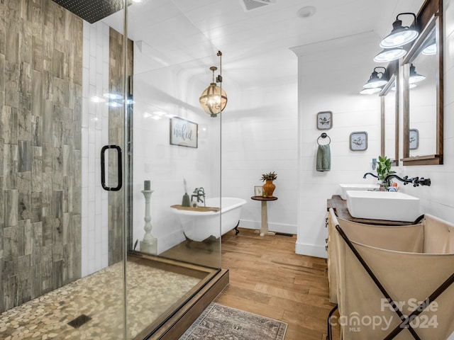 bathroom with hardwood / wood-style flooring, vanity, and plus walk in shower