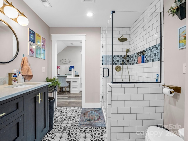 bathroom featuring hardwood / wood-style floors, vanity, toilet, and walk in shower