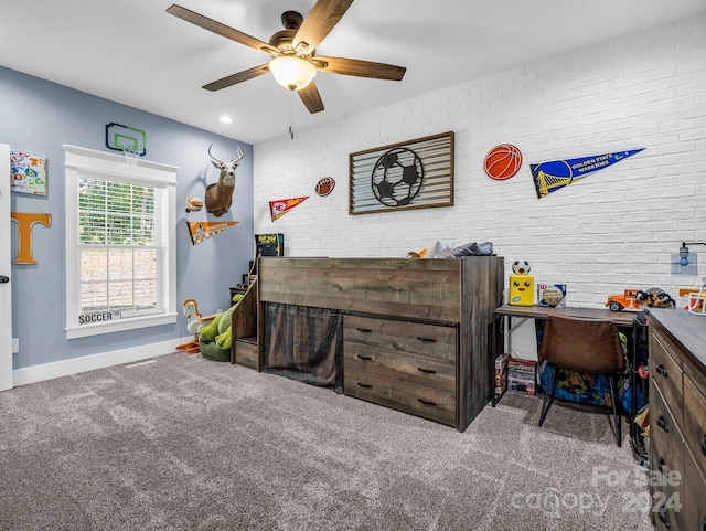 recreation room with ceiling fan, carpet, and brick wall