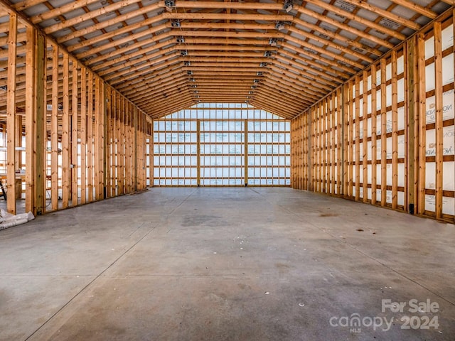 miscellaneous room featuring high vaulted ceiling and concrete floors