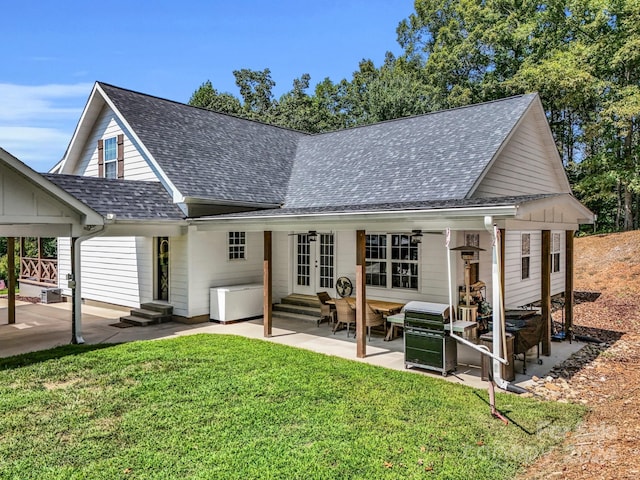 rear view of property with a lawn, a patio area, and french doors