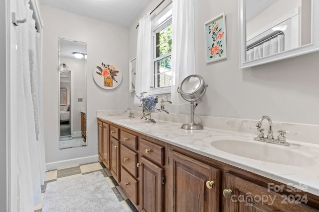 bathroom with a textured ceiling, vanity, and tile patterned floors