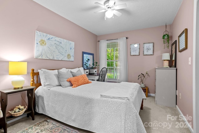 bedroom featuring light colored carpet, a textured ceiling, and ceiling fan