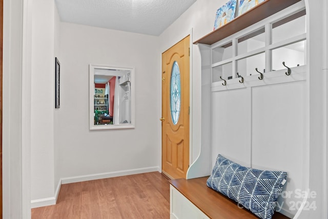 mudroom featuring a textured ceiling and light wood-type flooring