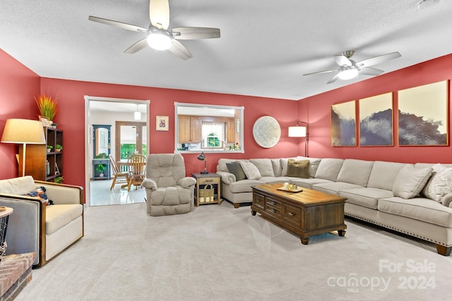 carpeted living room featuring a textured ceiling and ceiling fan