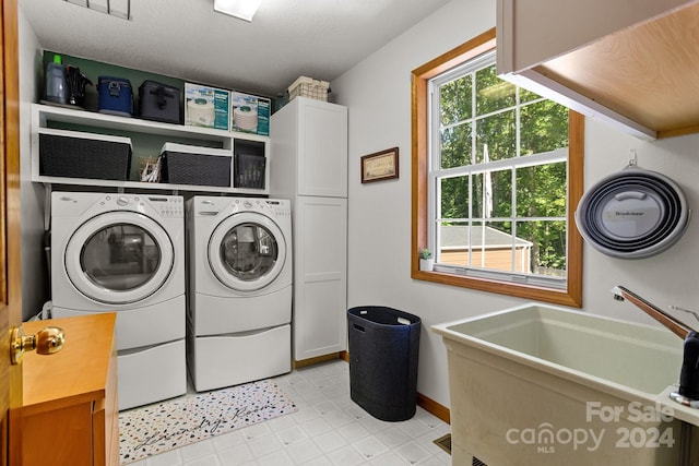 washroom featuring sink, light tile patterned flooring, cabinets, and washer and dryer