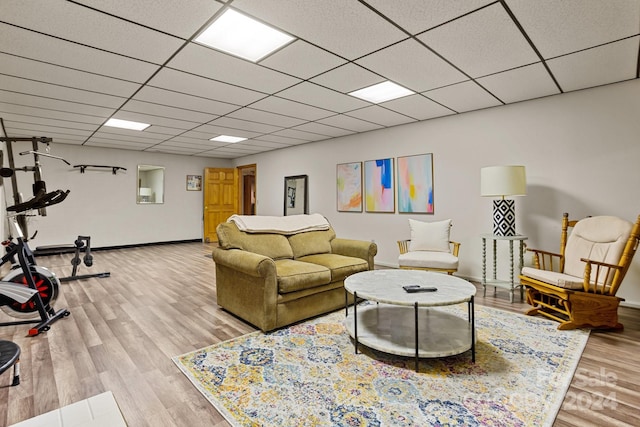 living room with light hardwood / wood-style flooring and a paneled ceiling