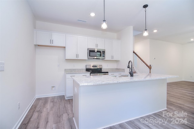 kitchen with light wood-type flooring, appliances with stainless steel finishes, sink, and white cabinetry