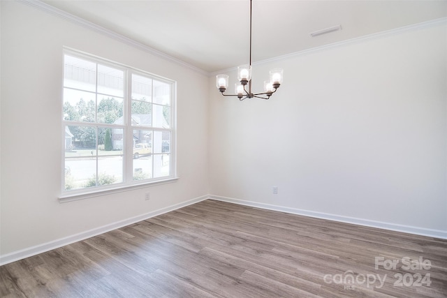 unfurnished room with crown molding, hardwood / wood-style floors, and a chandelier