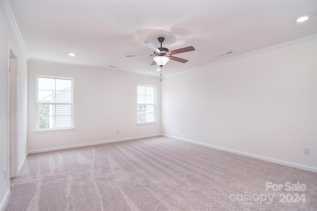 spare room featuring ceiling fan, light carpet, plenty of natural light, and crown molding