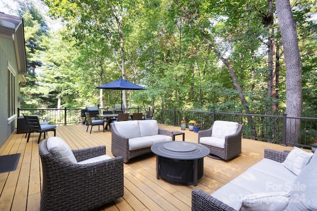 wooden deck featuring an outdoor living space with a fire pit