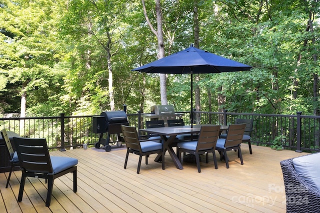 wooden terrace featuring area for grilling and outdoor dining area
