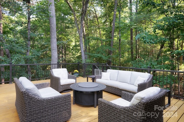wooden terrace with an outdoor living space with a fire pit