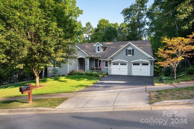view of front of home featuring a garage, stucco siding, a front lawn, and aphalt driveway