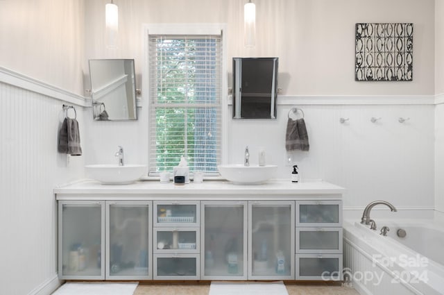 bathroom featuring vanity, a bathtub, and a wealth of natural light