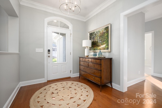 entrance foyer featuring a chandelier, hardwood / wood-style floors, plenty of natural light, and ornamental molding