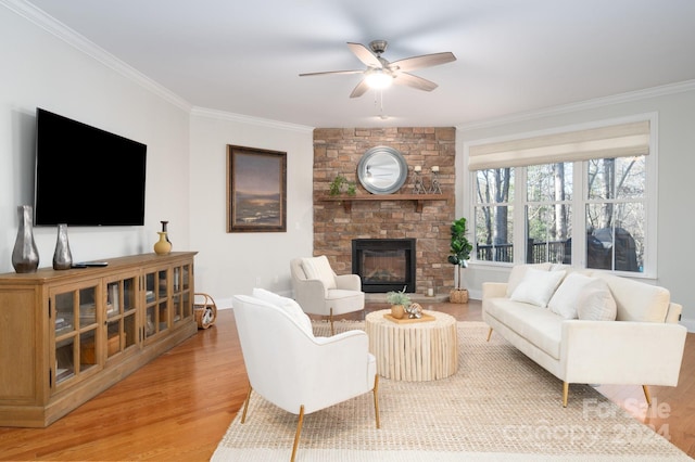 living room featuring a fireplace, wood-type flooring, ceiling fan, and crown molding