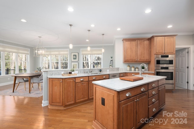 kitchen with pendant lighting, kitchen peninsula, sink, light hardwood / wood-style floors, and stainless steel double oven