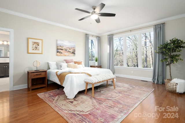 bedroom featuring hardwood / wood-style floors, ceiling fan, ornamental molding, and ensuite bath