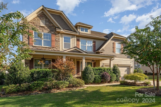 craftsman house featuring a porch, a garage, and a front yard