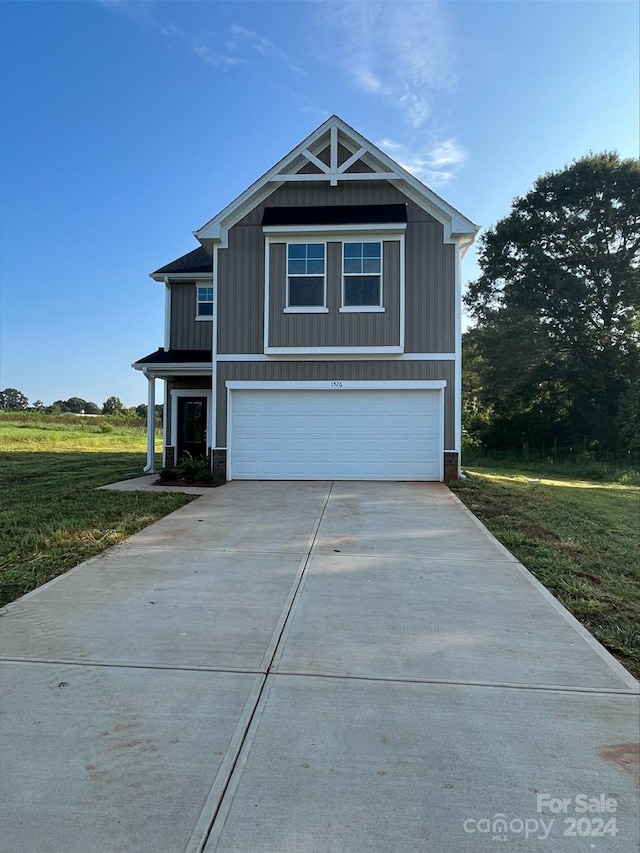 view of front of house featuring a front lawn and a garage