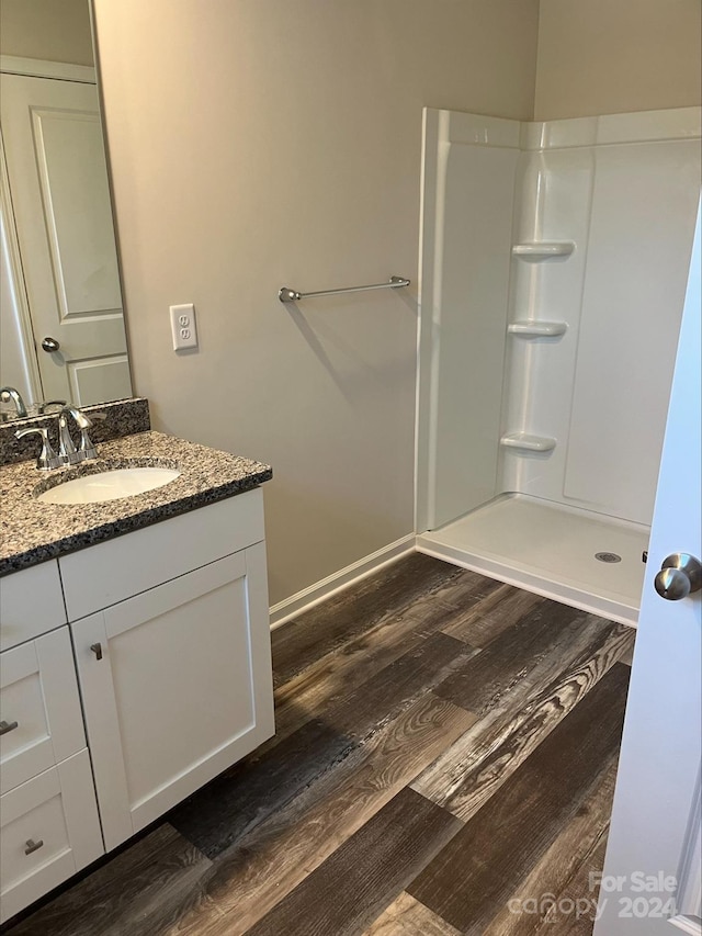 bathroom featuring vanity, hardwood / wood-style floors, and walk in shower