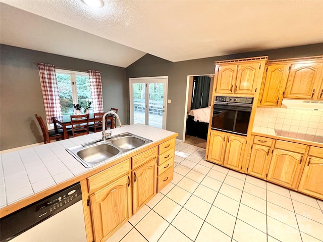 kitchen with vaulted ceiling, oven, white dishwasher, tile counters, and sink