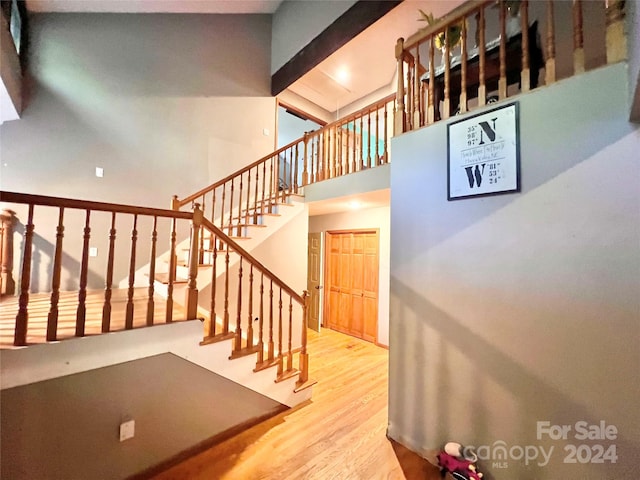 staircase featuring hardwood / wood-style floors and a high ceiling