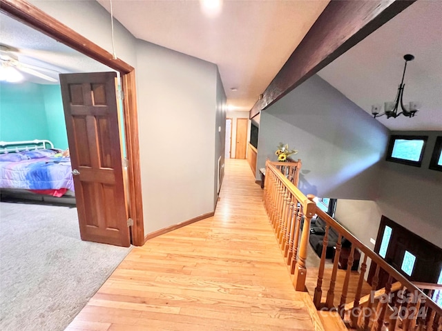 corridor featuring light hardwood / wood-style flooring and a chandelier