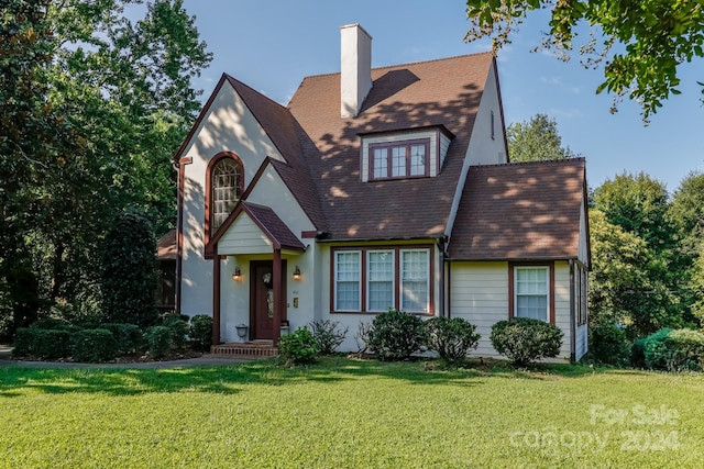 tudor home with a front lawn