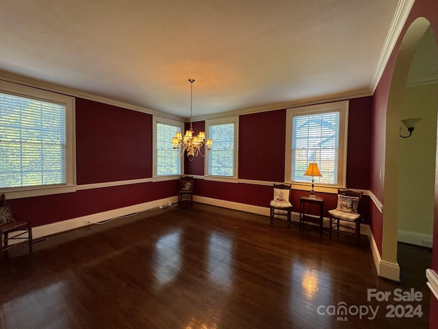 dining room featuring dark wood-type flooring, ornamental molding, and a notable chandelier