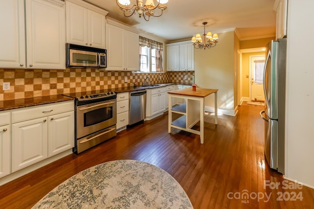 kitchen featuring a chandelier, dark wood-type flooring, hanging light fixtures, appliances with stainless steel finishes, and white cabinets