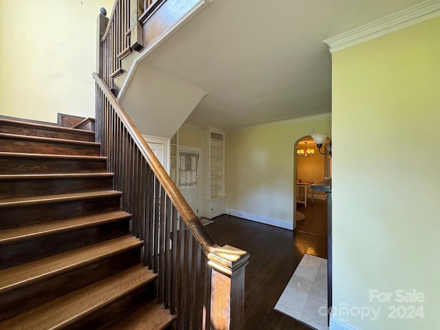 stairs with hardwood / wood-style floors and crown molding