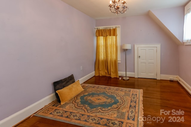 additional living space with hardwood / wood-style flooring and a notable chandelier